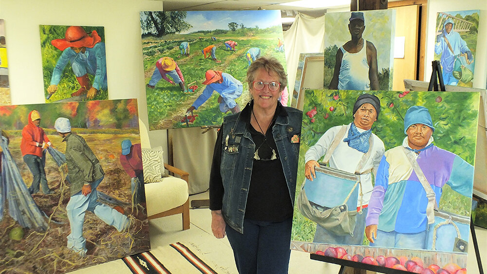 Masterson is surrounded by her paintings of migrant farmers in her studio.